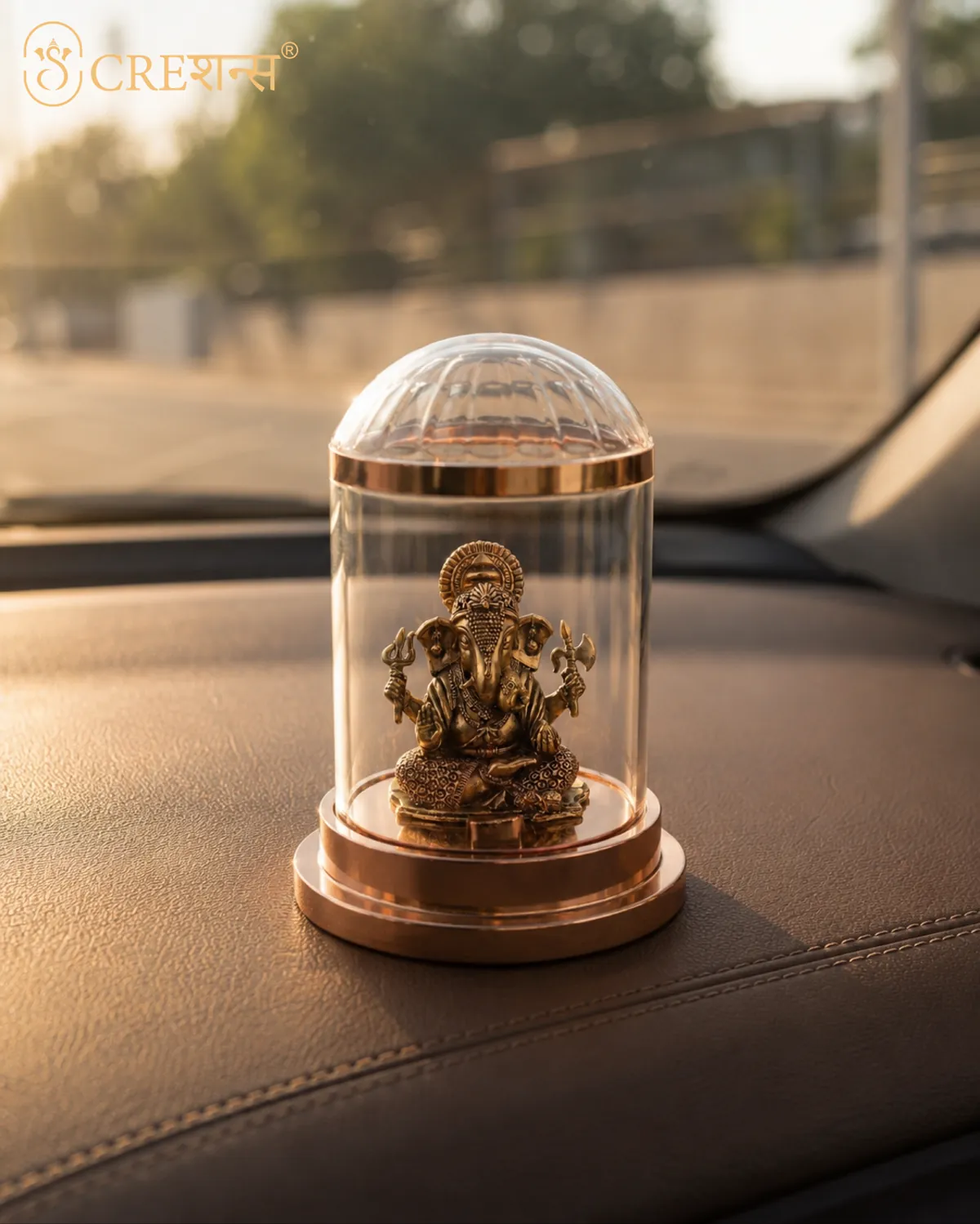 Rose-gold Ganesh cloche on a car dashboard