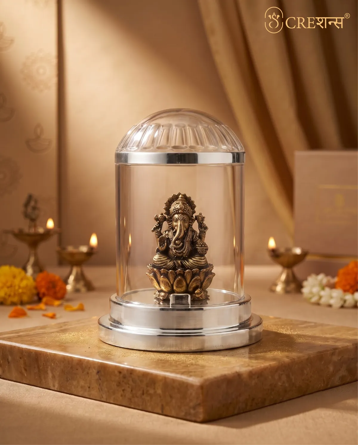 Silver Ganesh cloche on a marble prayer shelf with diyas